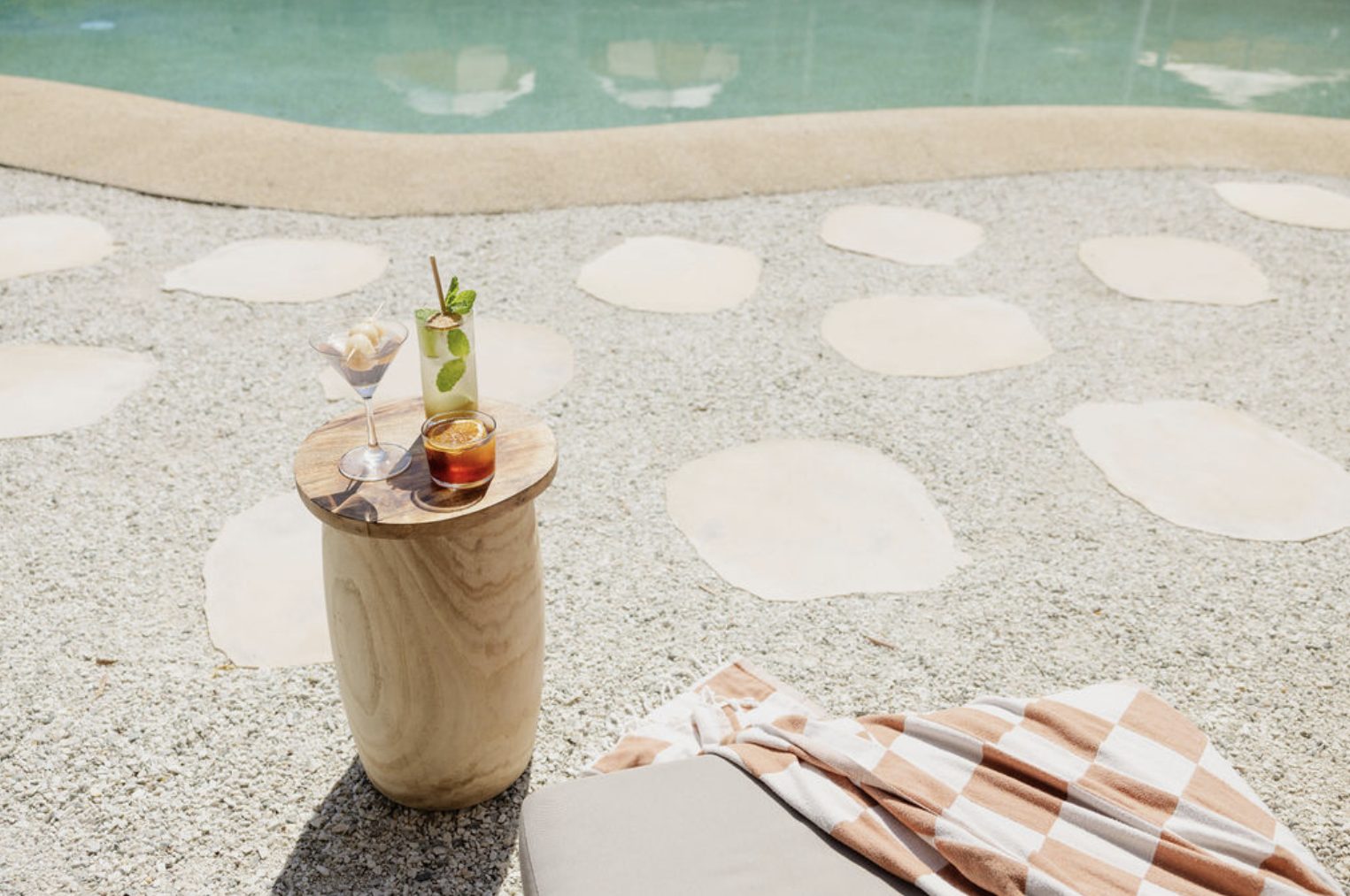 Los tragos sobre la mesa de madera, al borde de la piscina
