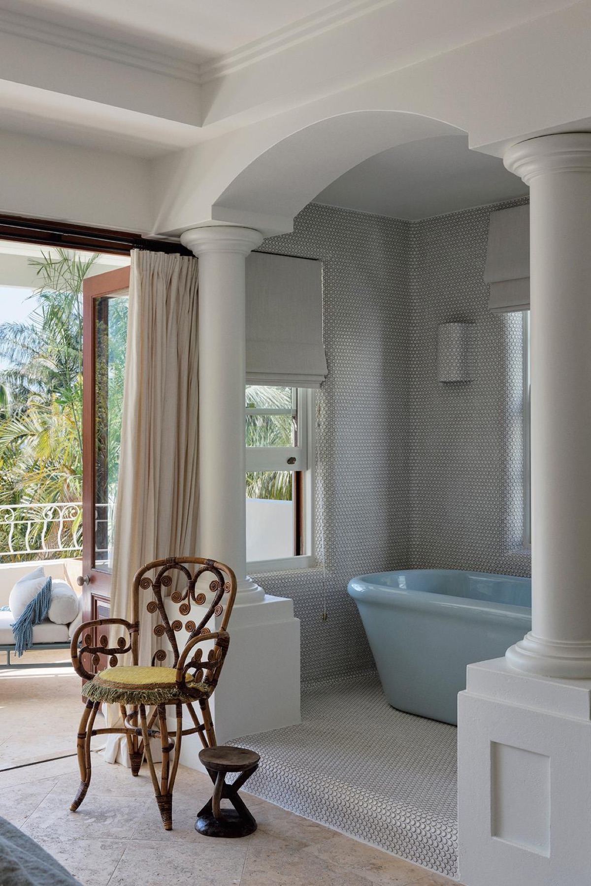 El baño con vista al balcón y las palmeras