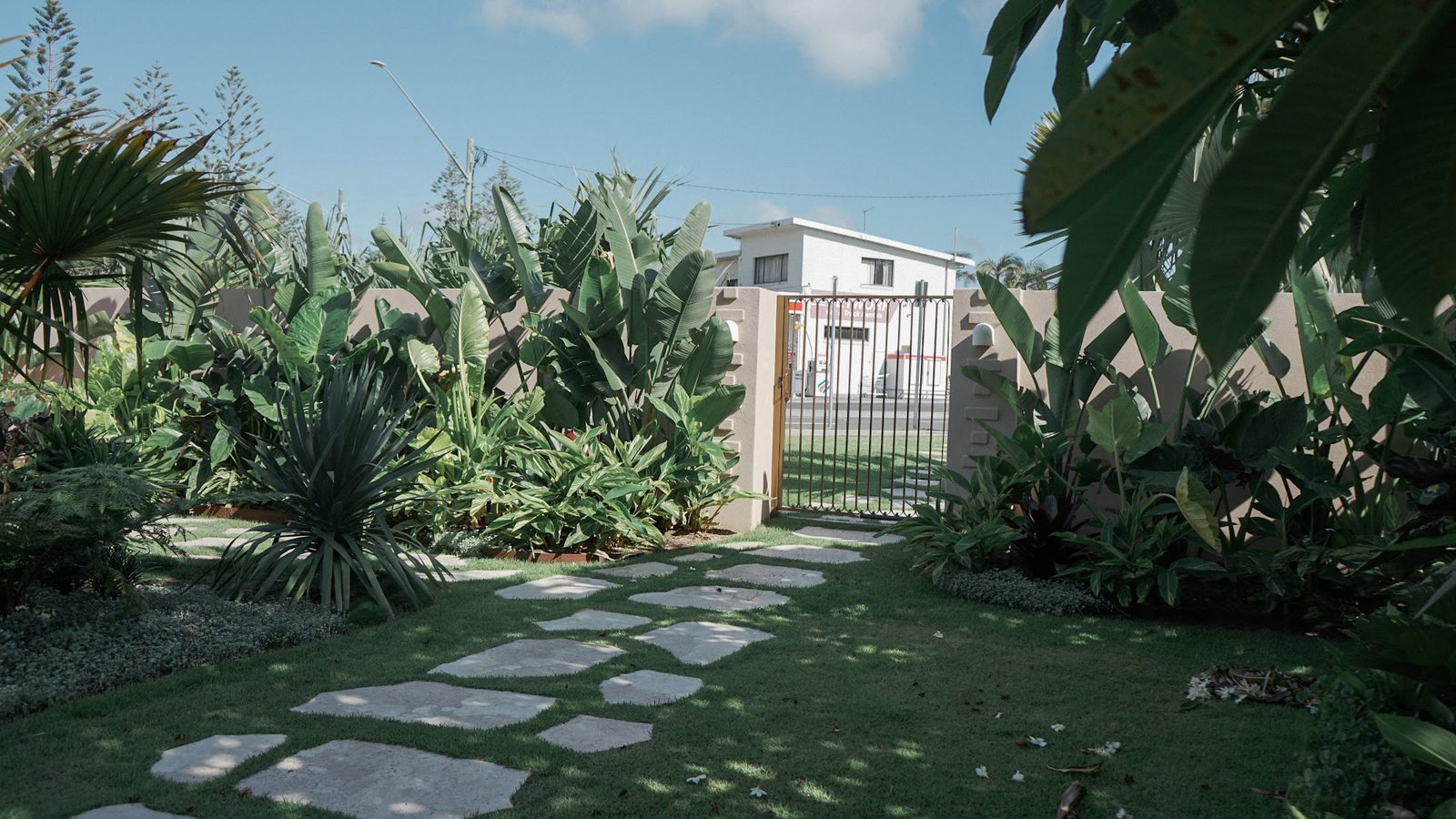El jardín de llegada y el portón peatonal