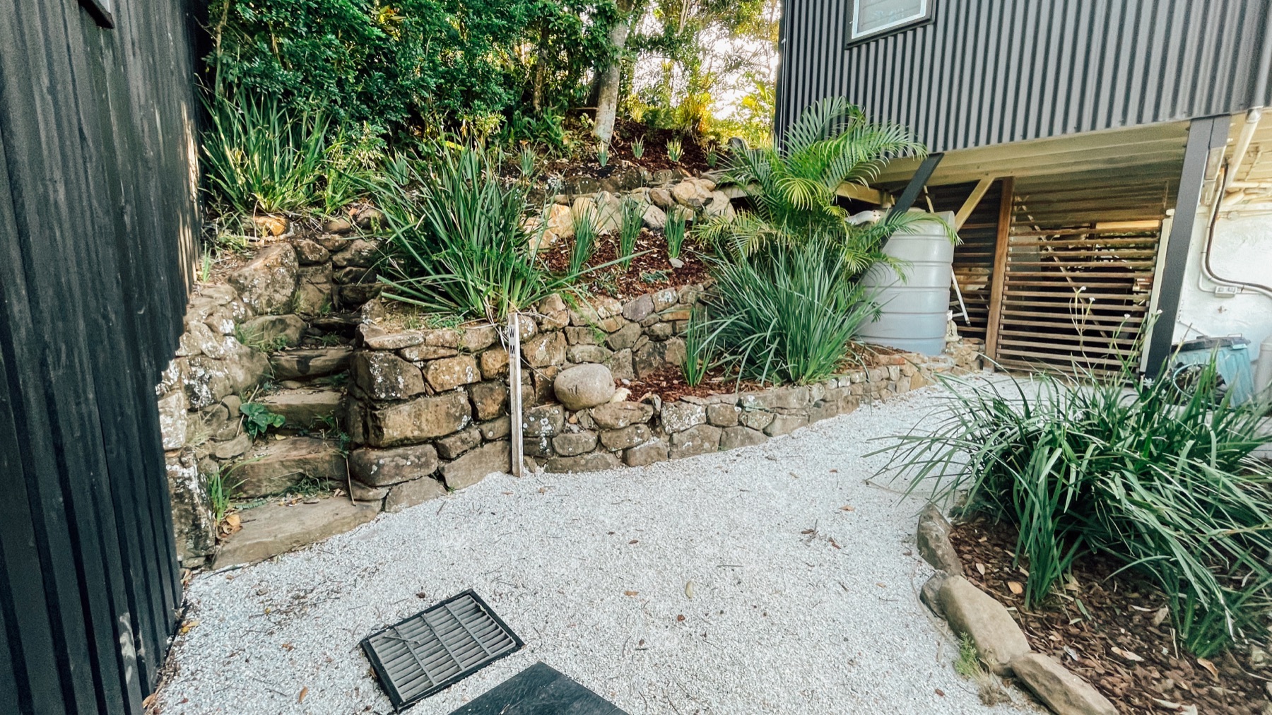 Muro de contención en piedra con escalones y plantación